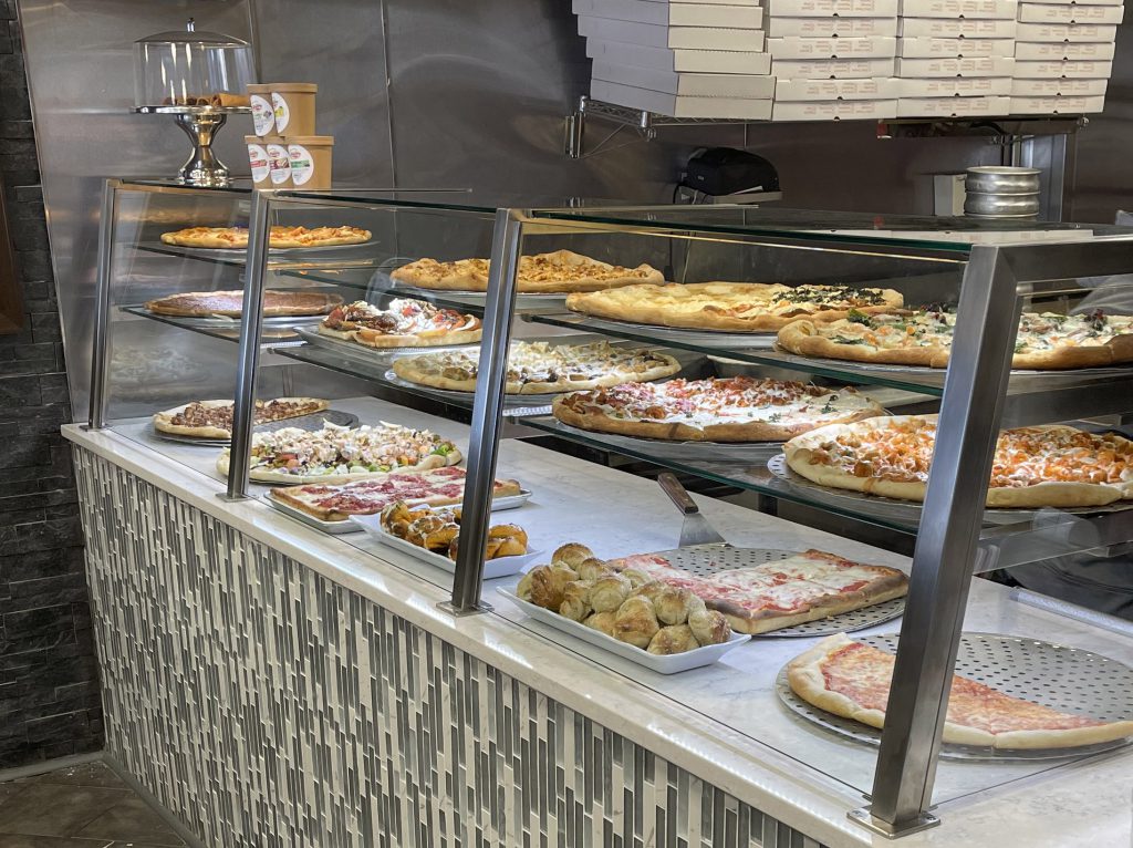 the pizza counter showing a variety of pizzas
